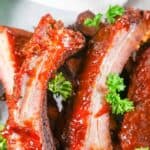 Homemade Chili's baby back ribs piled on a plate.