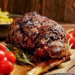 Oven roasted Indian style kashmiri leg of lamb on a cutting board.
