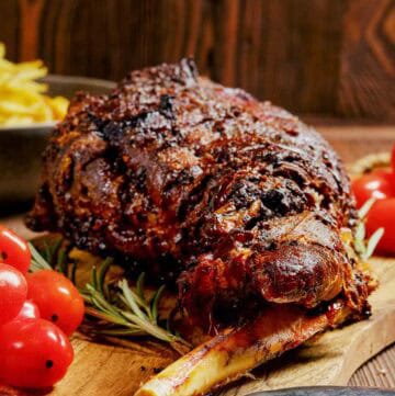 Oven roasted Indian style kashmiri leg of lamb on a cutting board.