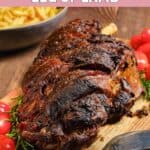 Oven roasted Indian style leg of lamb and tomatoes on a wood board.