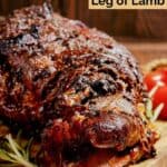 Oven roasted Indian style lamb leg on a wood board.