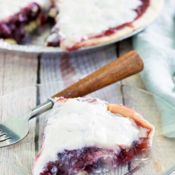 Copycat Marie Callender's sour cream blueberry pie and a slice on a plate.