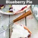 Homemade Marie Callender's sour cream blueberry pie and a slice on a glass plate.