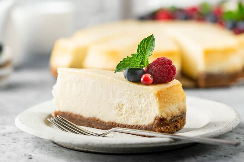 Classic New York style cheesecake slice on a plate.