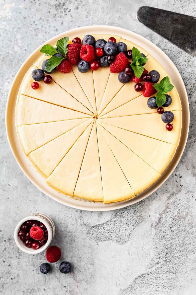 New York style cheesecake topped with berries and mint leaves.