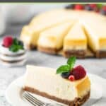 New York style cheesecake slice on a plate and the cheesecake behind it.