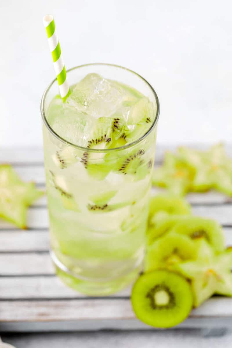 Copycat Starbucks kiwi starfruit refresher drink and slices of kiwi and starfruit by it.