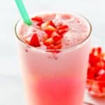 Copycat Starbucks pink drink garnished with chopped strawberries.