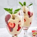 Homemade La Madeleine strawberries romanoff in stem wine glasses.