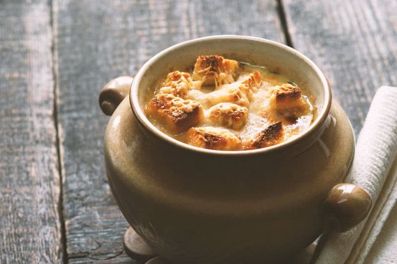 Copycat Brown Derby French onion soup on a wood surface.