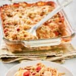 Chicken spaghetti casserole in a baking dish and a serving on a plate.