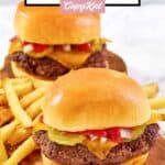Homemade chili's big qp burger and French fries on a wood board.