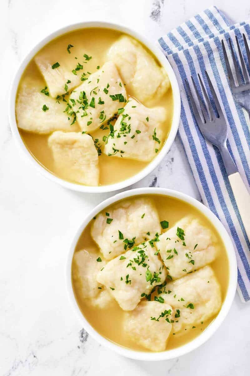 Copycat cracker barrel dumplings in bowls and forks next to them.