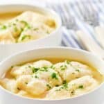 Homemade cracker barrel dumplings in two bowls and two forks.