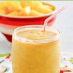 Homemade dole whip with rum float in a lowball glass and a bowl of pineapple chunks.