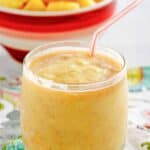 Homemade dole whip with rum float and a bowl of pineapple chunks behind it.