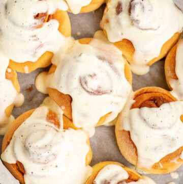 A pan of homemade cinnamon rolls with maple cream cheese frosting.