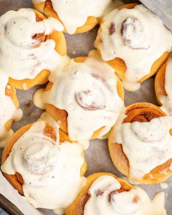 A pan of homemade cinnamon rolls with maple cream cheese frosting.