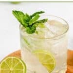 Homemade mojito cocktail and a lime next to it.