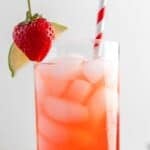 A glass of homemade Olive Garden Italian rum punch garnished with strawberry and lime.