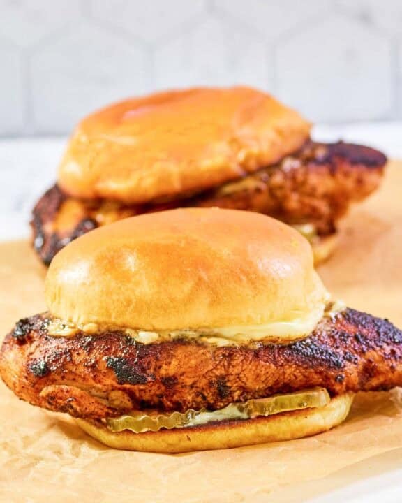 Copycat Popeyes blackened chicken sandwiches with mayo and pickles.