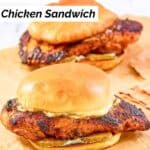 Two homemade Popeyes blackened chicken sandwiches on a marble surface.