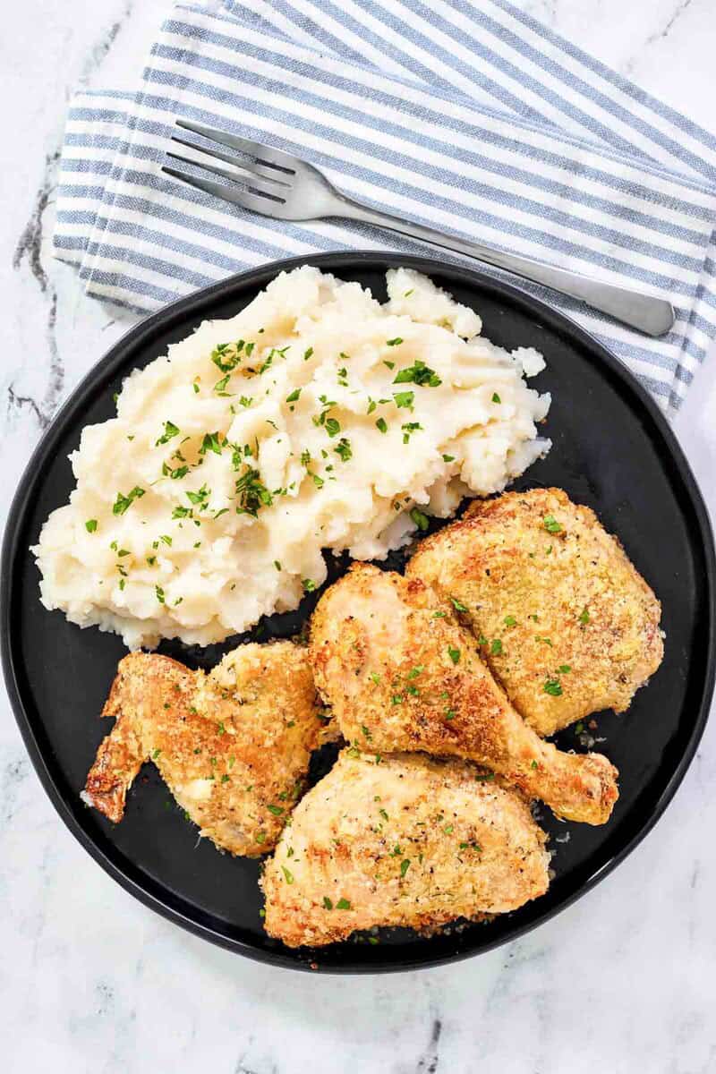 Crispy baked potato flake chicken and mashed potatoes on a plate.