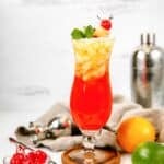 Homemade Red Lobster mai tai, an orange, a lime, and bowl of cherries.