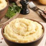 Homemade simple mashed potatoes, forks, and a pepper grinder.