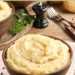 Homemade mashed potatoes, forks, and a pepper grinder.