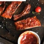 Homemade St. Louis style BBQ sauce on ribs and in a small cup.