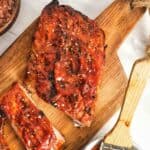 Homemade St. Louis style barbecue sauce in a cup an on ribs.