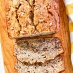 A loaf of homemade Starbucks banana bread on a wood cutting board.
