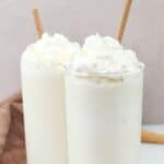 Two homemade Starbucks vanilla bean frappuccino drinks on a marble surface.