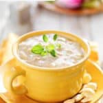 A bowl of homemade Sweet Tomatoes clam chowder and oyster crackers next to it.