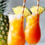 Homemade TGI Friday's Captain Morgan island rum punch in two hurricane glasses.