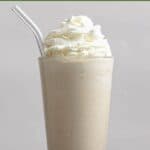 Homemade Chick-fil-A frosted coffee with a straw and coffee beans around it.