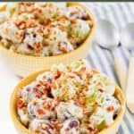 Homemade chicken salad chick grape salad in two bowls and two spoons next to them.