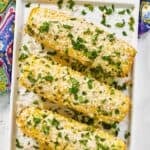 Four copycat Chili's roasted street corn on the cob on a platter.