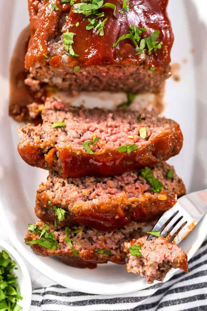 Mamma Joe's meatloaf on a platter and a fork with a piece on it.