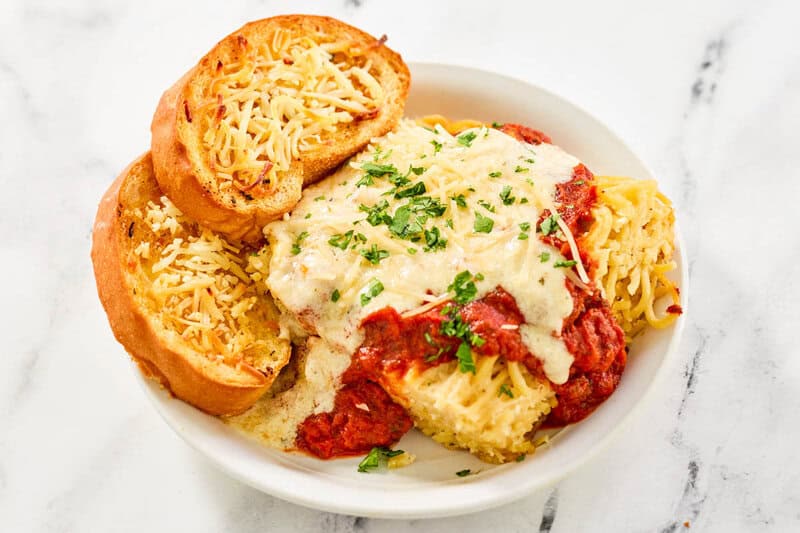 Copycat Marie Callender's garlic toast in a bowl with lasagna.