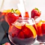A glass of copycat Olive Garden sangria garnished with a strawberry.