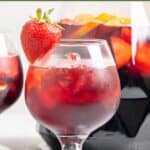 Homemade Olive Garden sangria in a glass and in a pitcher behind it.