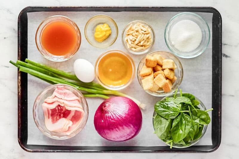 Copycat Simon and Seafort's mustard dressing and salad ingredients on a tray.