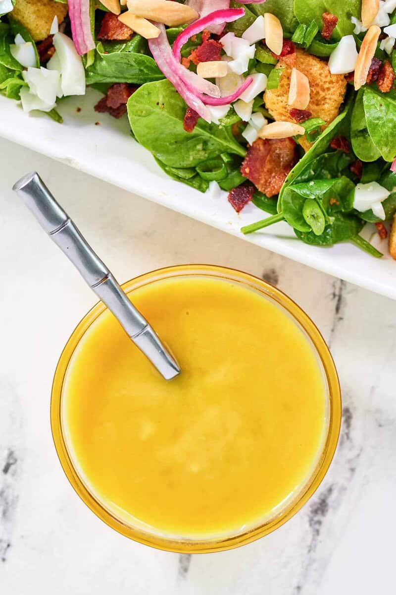 A salad and a small bowl of copycat Simon and Seafort's mustard dressing.