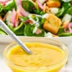 A bowl of homemade Simon and Seafort's must dressing and a salad behind it.
