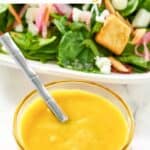 A small bowl of homemade Simon and Seafort's mustard dressing with a spoon in it.