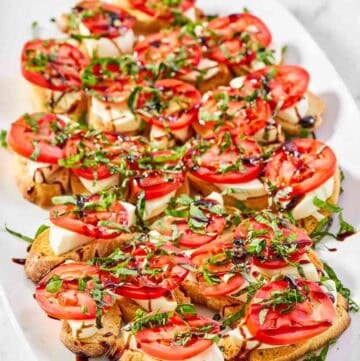 Copycat spaghetti warehouse caprese bruschetta on a marble surface.