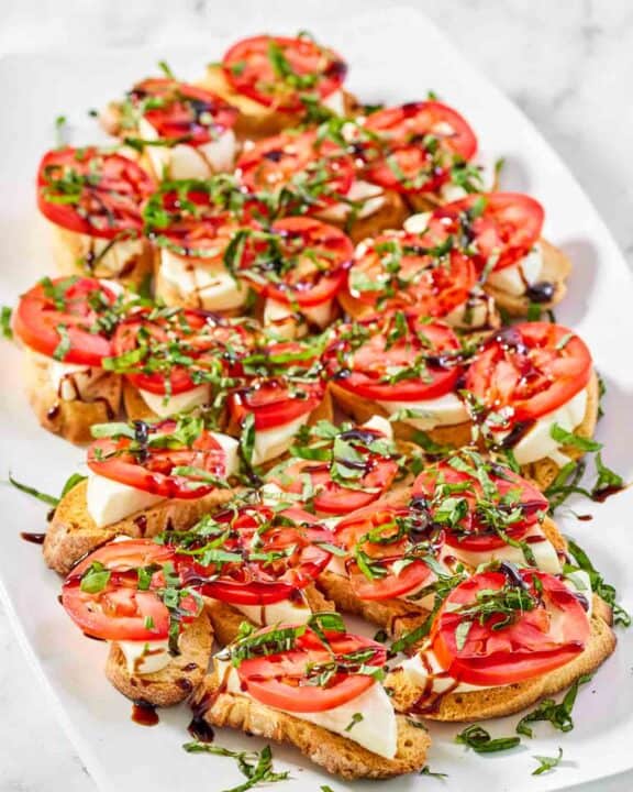 Copycat spaghetti warehouse caprese bruschetta on a marble surface.