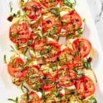 Homemade spaghetti warehouse caprese bruschetta appetizer on a marble surface.